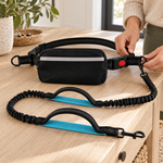 Adjustable waist belt buckle and complete black bungee leash on an oak console